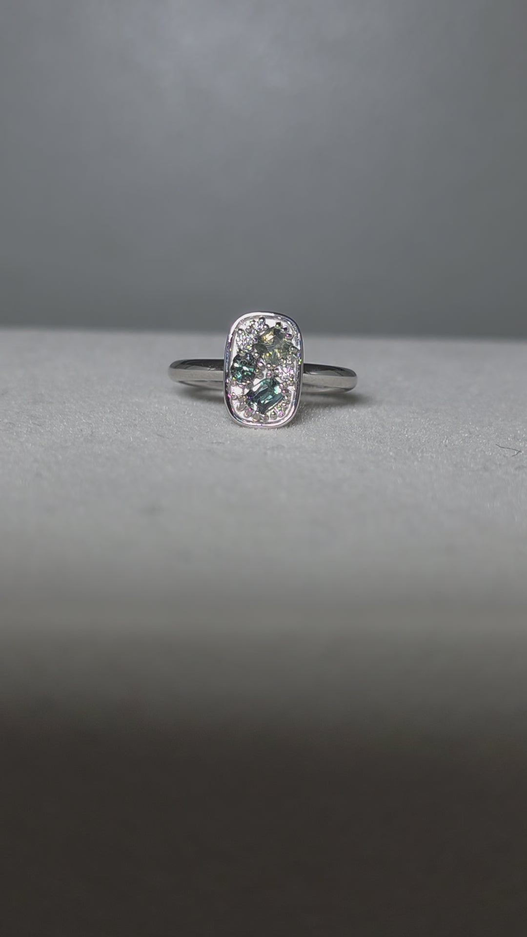 video of alexandrite and diamonds ring in platinum under different lighting conditions

