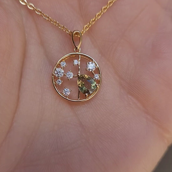 video of hand holding a Natural Alexandrite and Diamond Pendant in 18K Yellow Gold – 0.63ct Pear Cut in neutral background