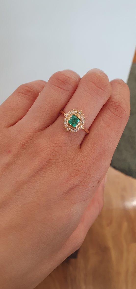 view on hnad of Art Deco Inspired Colombian Emerald Ring with Diamond Halo in 18K Yellow Gold