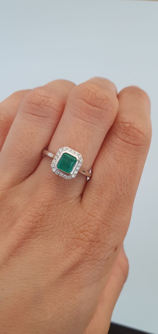 photo on hand of Emerald Cut Colombian Emerald Ring with Diamond Halo in Platinum - 1982791