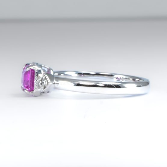 side view on white background of 1.05ct Natural Unheated Emerald Cut Pink Sapphire Ring in Platinum 950 with Diamond Accents and Filigree Detail