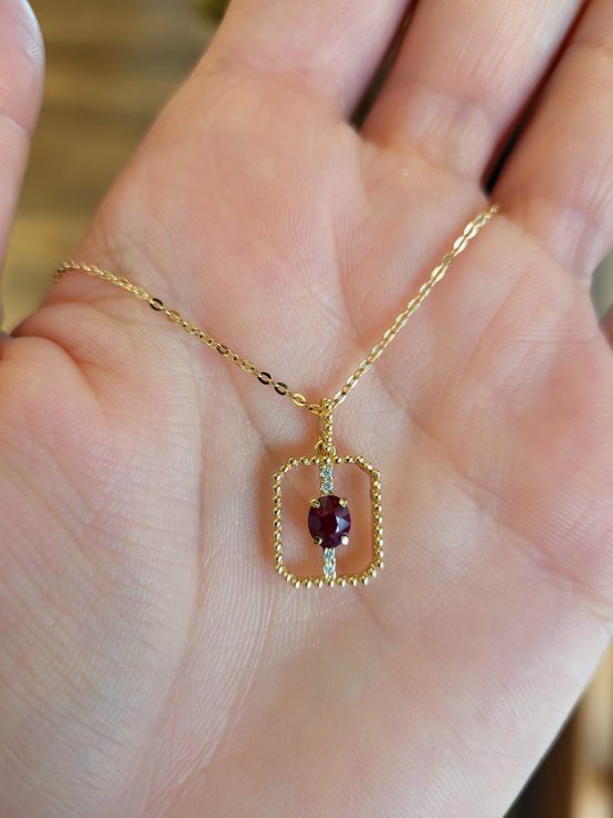 photo on hand of 0.54ct Natural Ruby Pendant in 18K Yellow Gold with Diamond Accents