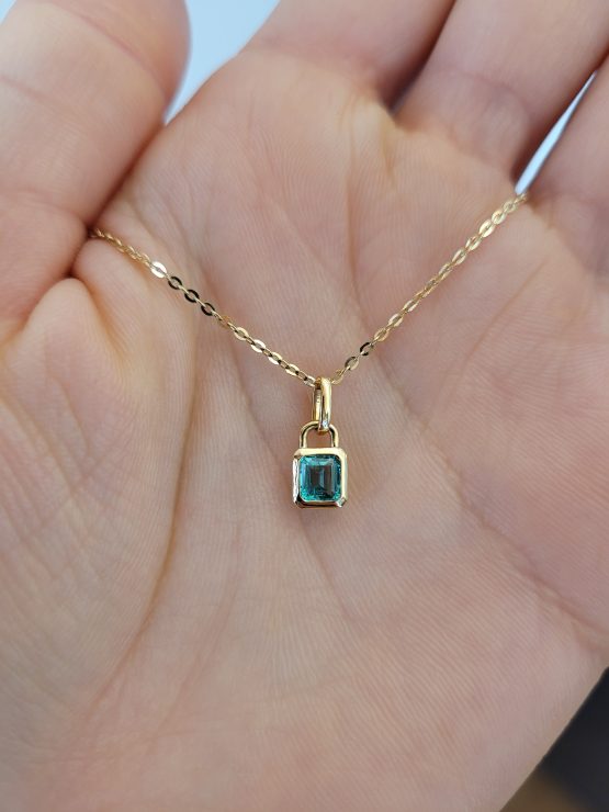 photo on hand of 0.33ct Vivid Green Colombian Emerald Pendant in 18K Yellow Gold