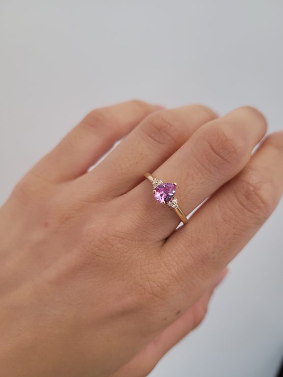 photo on hand of Unheated Pear Cut Pink Sapphire Ring with Diamond Cluster in 18K Yellow Gold