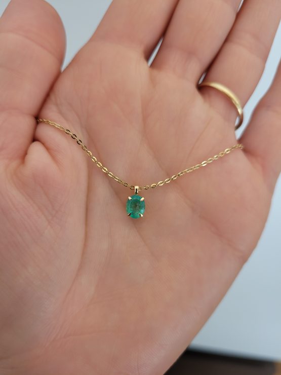 photo on hand of 0.56ct Oval Colombian Emerald Pendant in 18K Yellow Gold