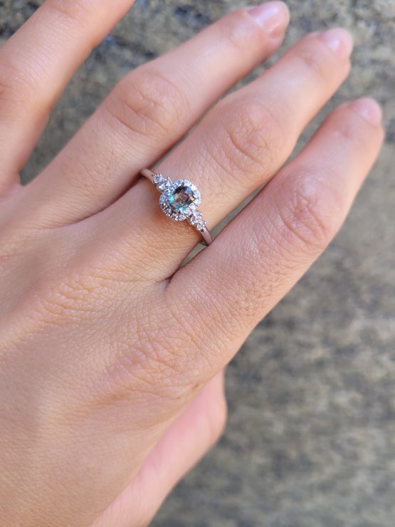 photo on hand of Platinum Alexandrite Ring with Diamond Halo and Side Accents