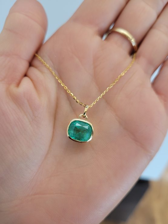 photo on hand of 3.08ct Cushion Cut Colombian Emerald Pendant in 18K Yellow Gold