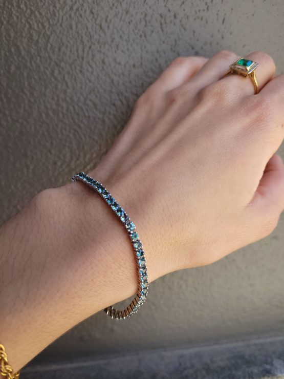 photo on hand of Australian Teal Sapphire Tennis Bracelet in Platinum 950