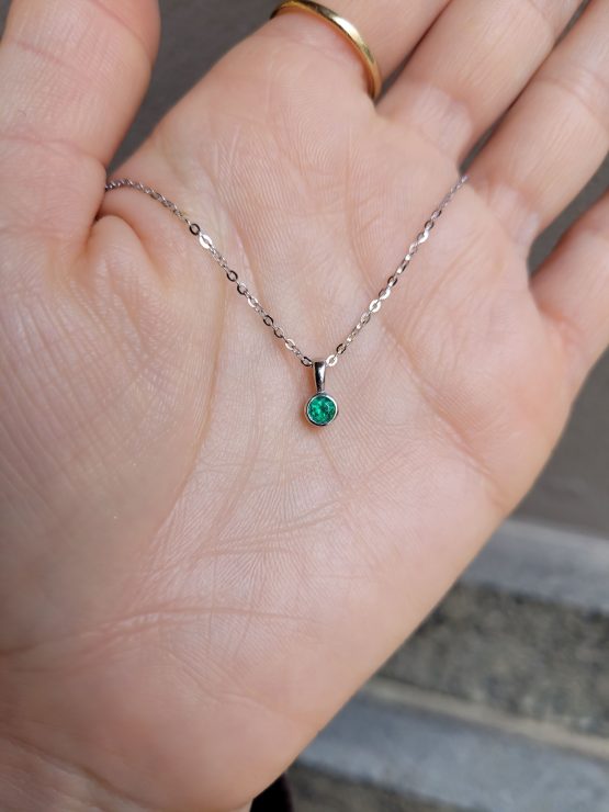 view on hand of Round Emerald Solitaire Pendant in Platinum with Vivid Green 0.18ct Stone - 1982874